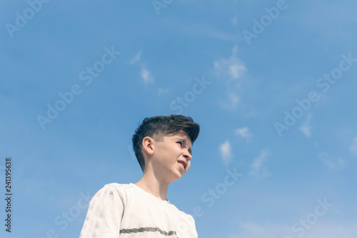 Bottom view a boy face on the blu sky background. Travel concept