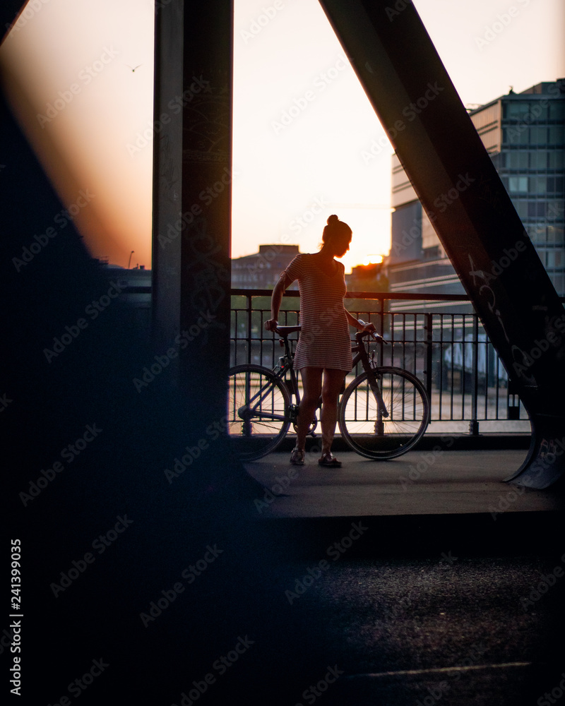 Young woman with bike in urban scenery