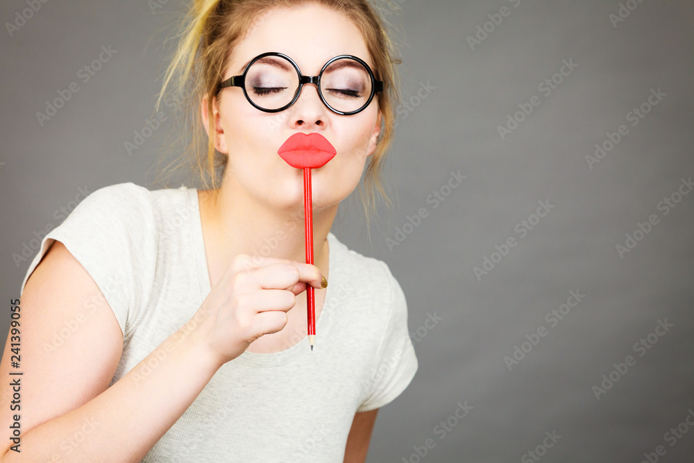 Happy woman holding fake lips on stick