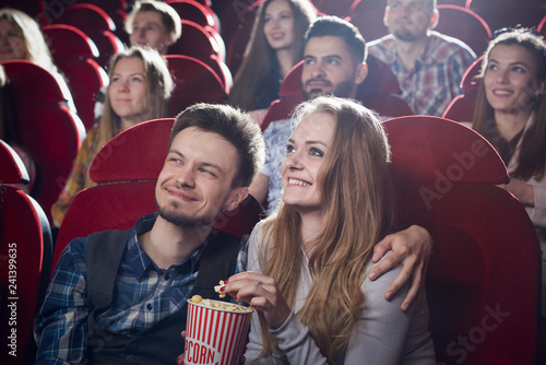 Couple sitting together in cinema, watching comedy.
