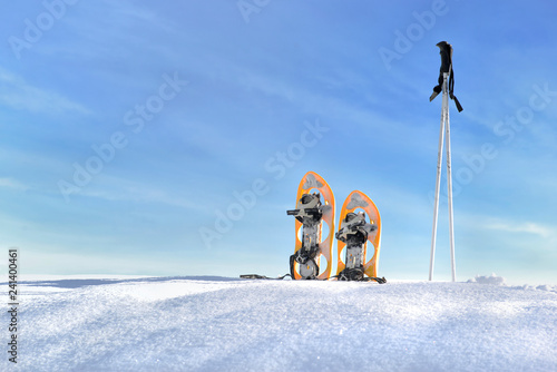 snowshoes and sticks on the snow under blue sky photo