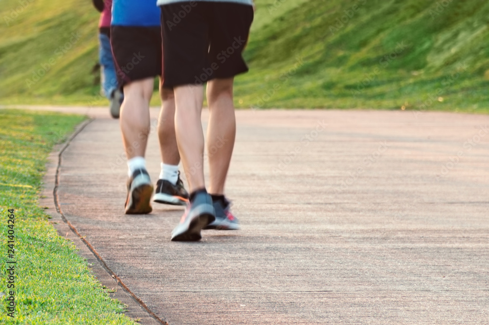 Low angle view of runners running in park. Blurred feet motion group of runners, Fitness and healthy lifestyle, outdoor sport activity. Empty place for text, copy space.