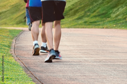 Low angle view of runners running in park. Blurred feet motion group of runners, Fitness and healthy lifestyle, outdoor sport activity. Empty place for text, copy space.