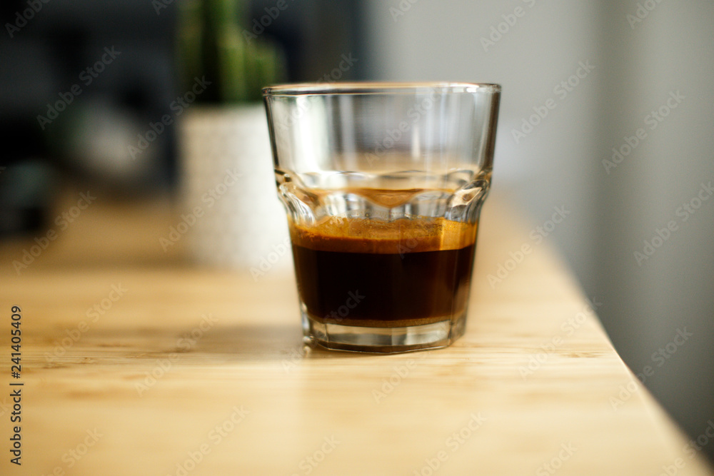 A glass of iced espresso lying on a wooden table A glass of iced espresso lying on a wooden table