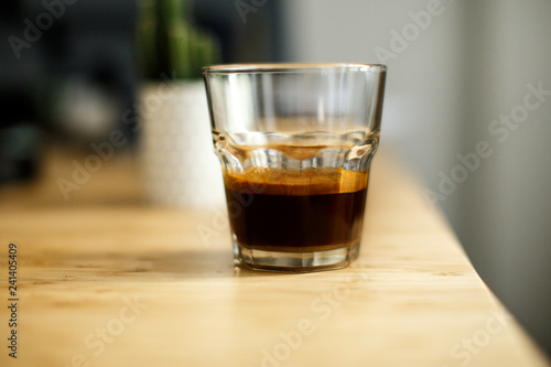 A glass of iced espresso lying on a wooden table