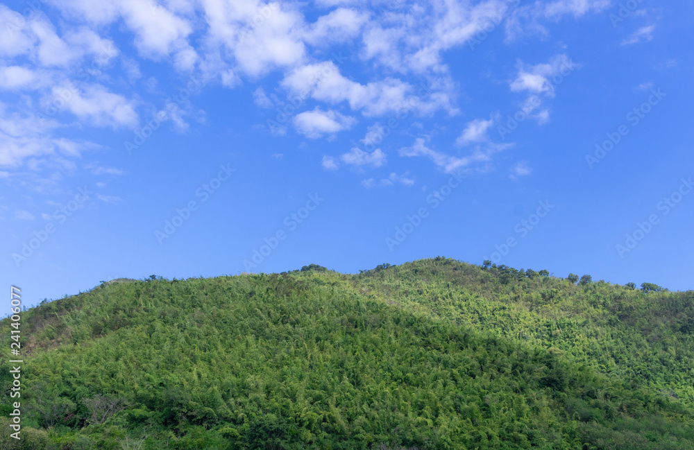 bright green mountain against blue sky with copy space on sky