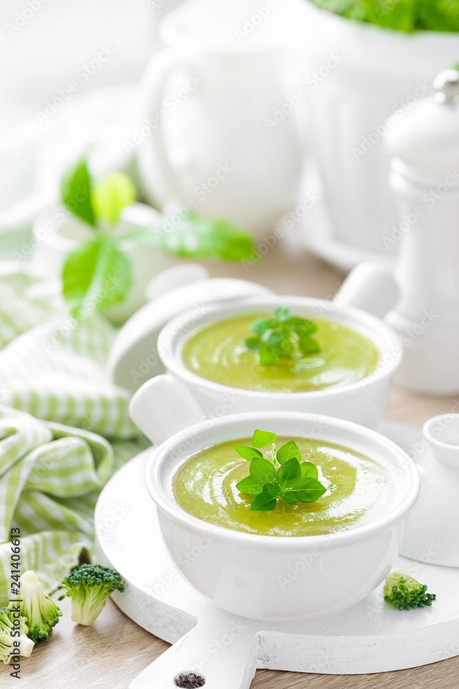 Broccoli soup in bowls on wooden kitchen table closeup. Healthy vegetarian dish. Diet food Broccoli soup in bowls on wooden kitchen table closeup. Healthy vegetarian dish. Diet food