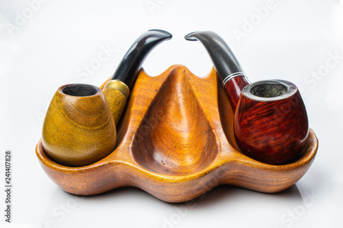 Two pipes on a wooden stand