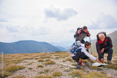 adventure, travel, tourism, hike and people concept - group of smiling friends with backpacks and map outdoors