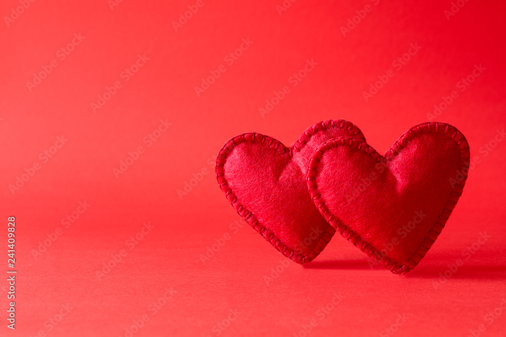 Felt hearts on red background with bokeh. Valentine's day celebration or love concept. Copy space