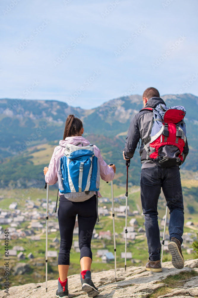 Portrait of happy couple hiking in the countryside at summer