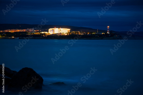 Gelendzhik lighthouse in the evening twilight. Thick Cape, cliff, Black sea. Rocks and waves. Long exposure