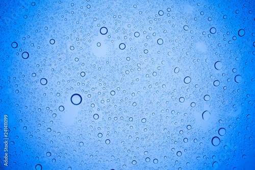 Rain droplets on blue glass background  Water drops on blue glass.