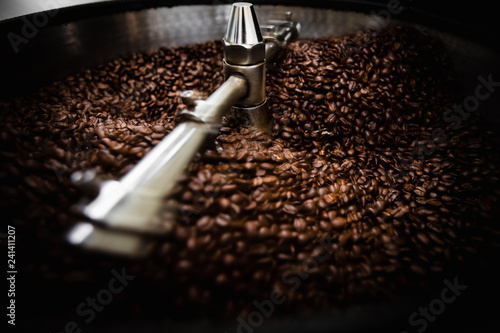  roasted spinning cooler professional machines and fresh brown coffee beans movement close up dark photo