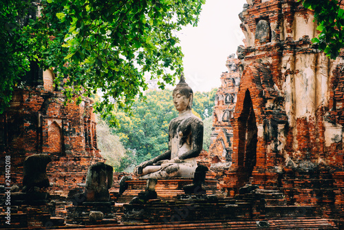 Thailand, Ayutthaya, Buddha statue surrounded by brick pagodas at Wat Mahathat photo