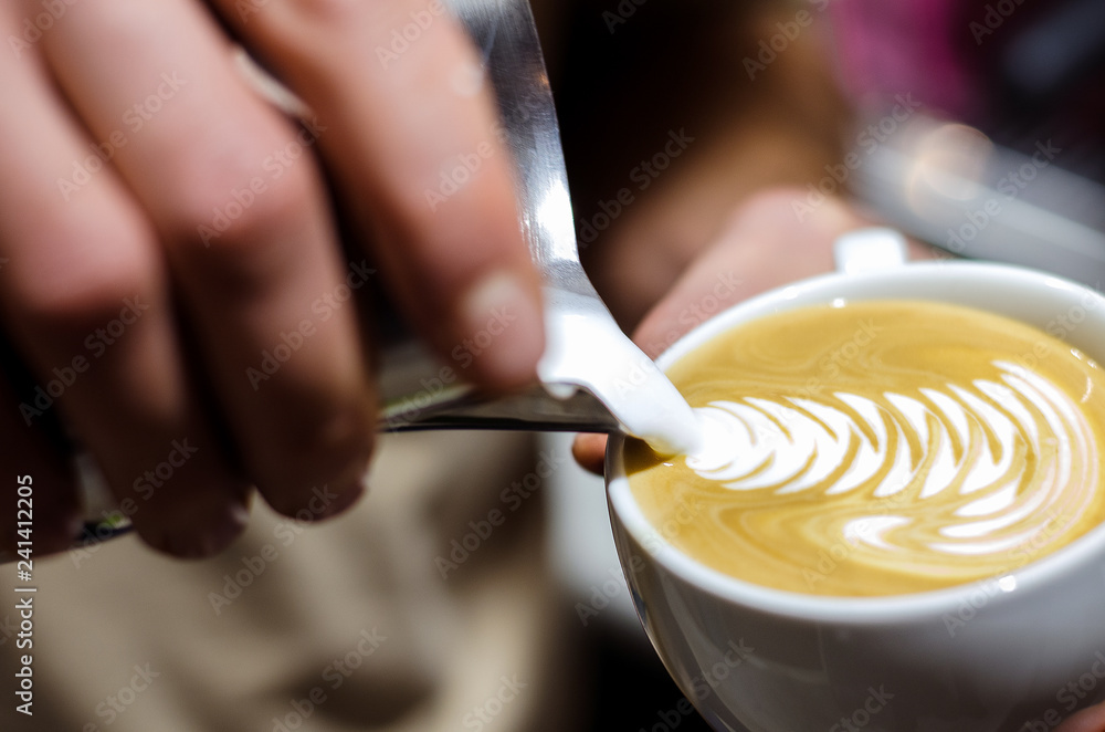 Closeup of making beautiful latte art with milk in an espresso cup Closeup of making beautiful latte art with milk in an espresso cup