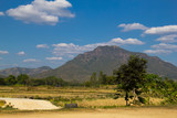 Beautiful mountains, rice straw in the fields, white cloud and blue sky background.