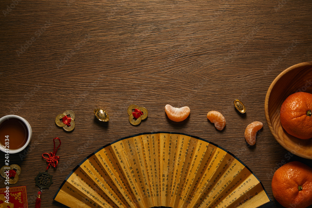 Φωτογραφία top view of fresh ripe tangerines, cup of tea, fan with hieroglyphs and golden c
