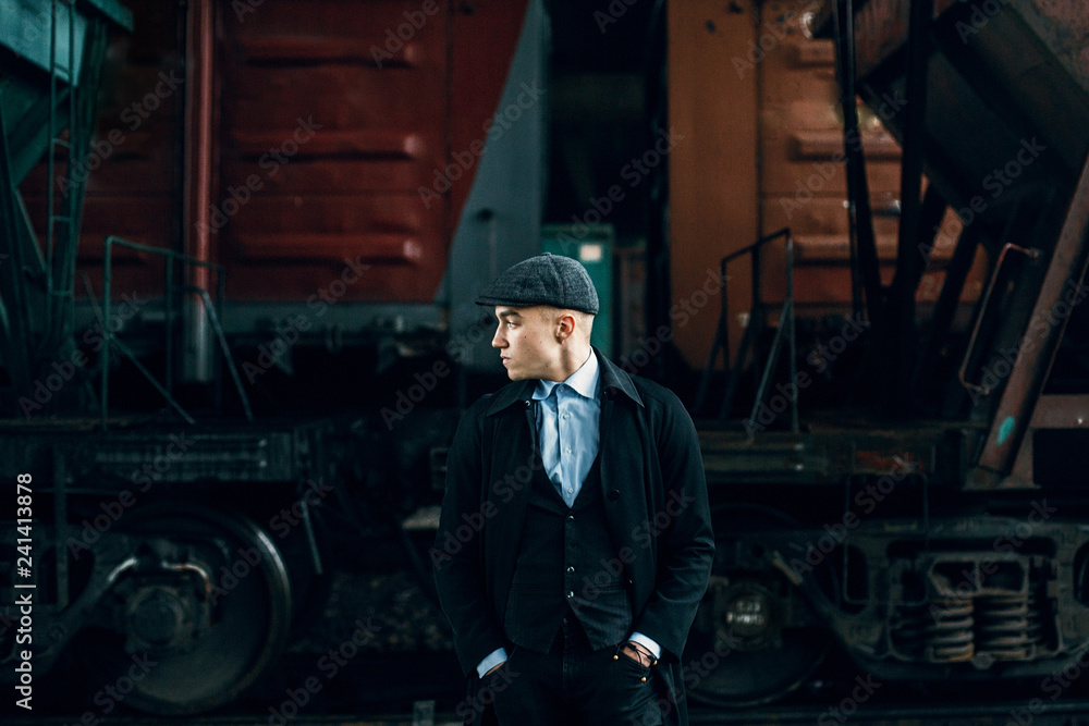 Φωτογραφία stylish gangster in tweed outfit posing on background of railway carriage