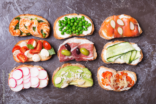 Set of colorful sandwiches prepared with different ingredients such as fish, vegetables and meat