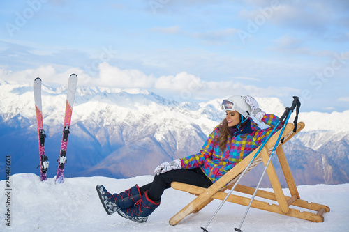 Women at mountains in winter with sun-lounger