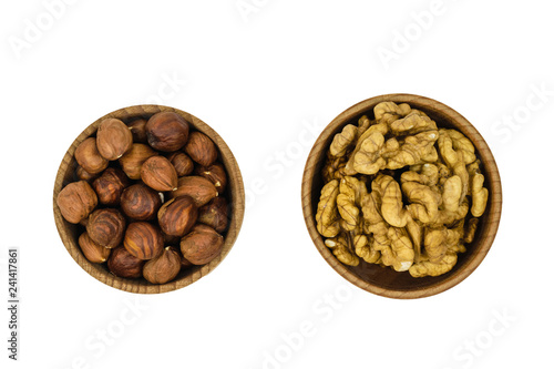 Wooden brown bowl with hazelnuts and wallnuts isolated on white background. The view from the top.