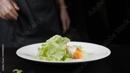 Wallpaper Mural Lettuce leaf falling down in slow motion on dish with freshfried salmon fillet placed on white plate. Fine dining concept. hd Torontodigital.ca