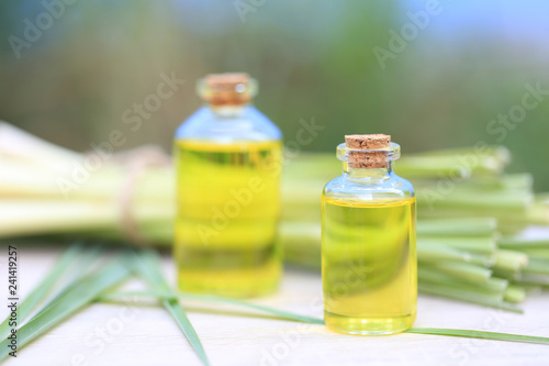 Lemongrass essential oil in glass bottles on natural green background