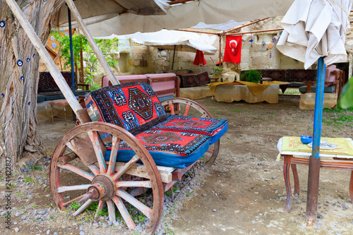 Old wooden cart as a soft chair at a table in the courtyard of the Turkish yard. photo