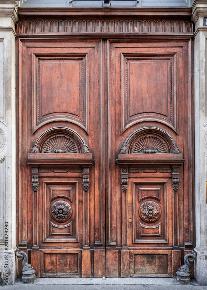 finely decorated wooden entrance door of an 18th century Milan palace, Italy