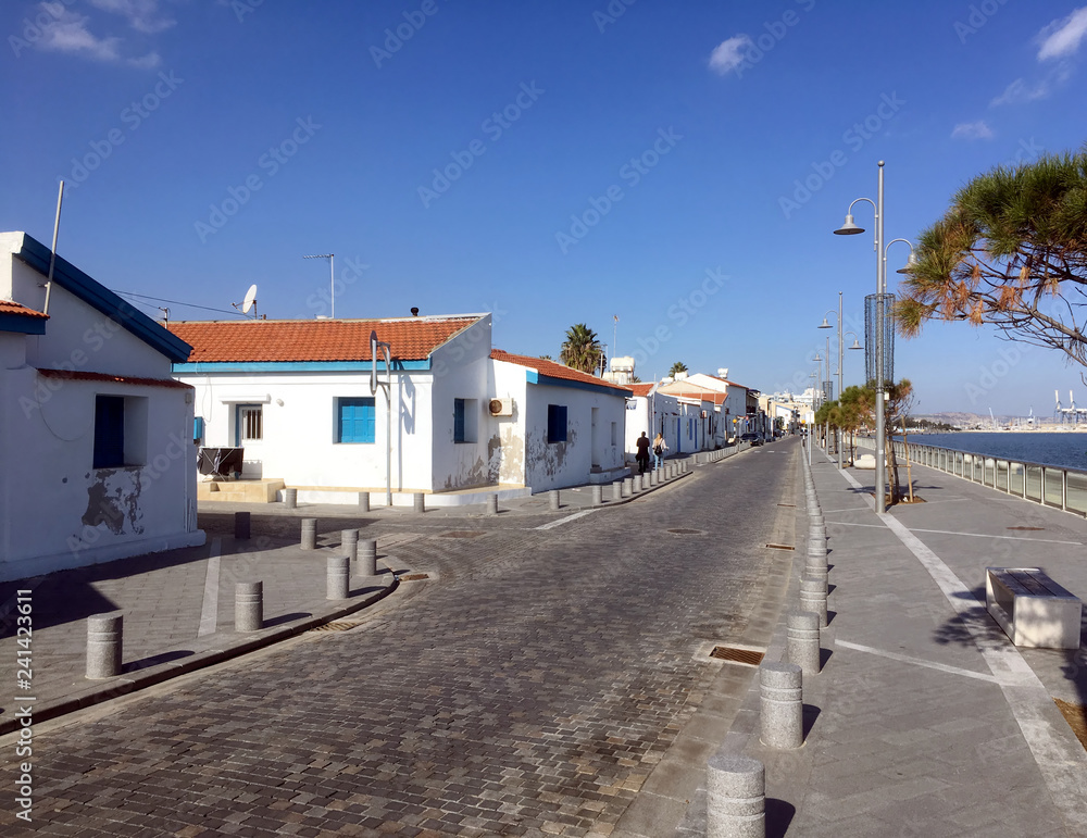 Typical southern seaside cityscape in Cyprus with street and white houses on bright sunny day in the off-season time in winter