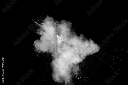 Freeze motion of white dust particles on black background. White powder explosion.
