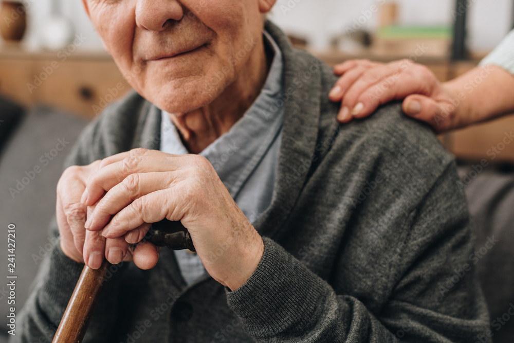 cropped view of happy pensioner with wife hands on shoulder