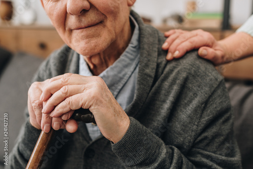 cropped view of happy pensioner with wife hands on shoulder © LIGHTFIELD STUDIOS