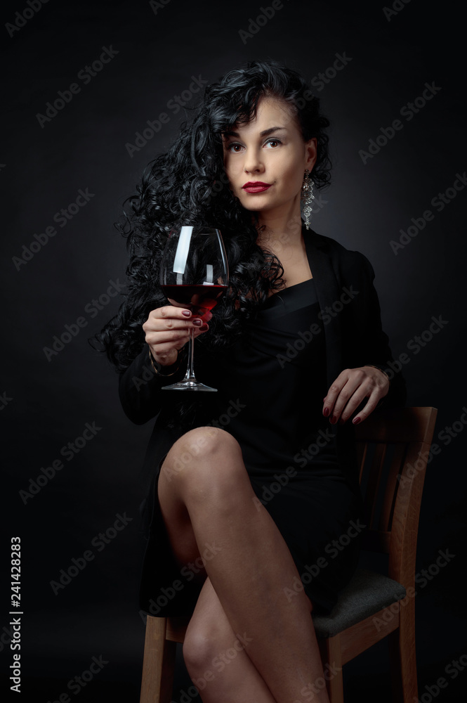 Portrait of attractive brunette with glass of wine on a black bacground. Portrait of attractive brunette with glass of wine on a black bacground.