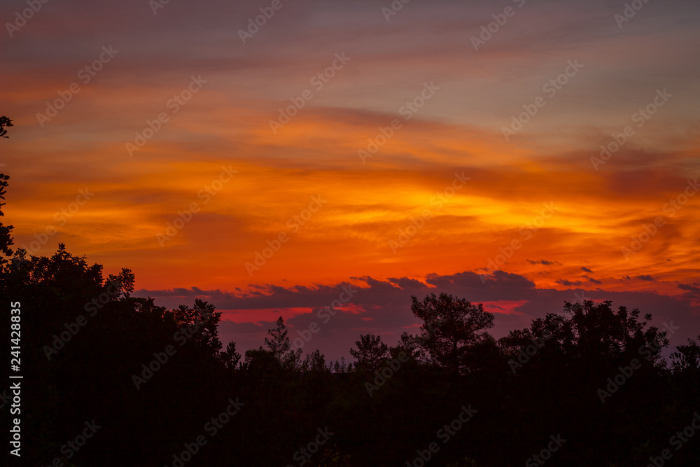 Autumn evening skies, Beautiful orange sun set over the peaceful Mountains in the Mediterranean, Cyprus Autumn evening skies, Beautiful orange sun set over the peaceful Mountains in the Mediterranean, Cyprus