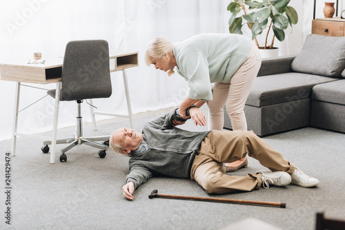 old woman helping husband who falled down with heart attack