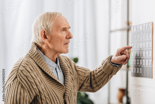 old man looking at calendar and remembering dates photo