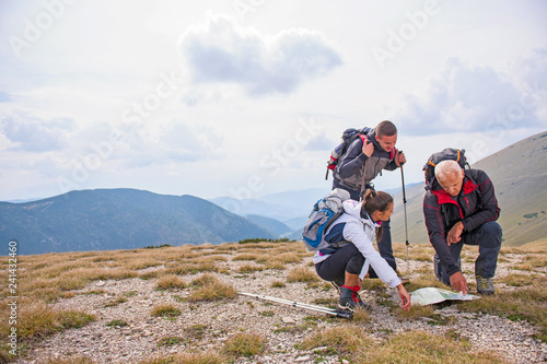 adventure, travel, tourism, hike and people concept - group of smiling friends with backpacks and map outdoors