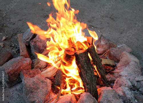 Bonfire in a tourist camp lined with stones around the hill