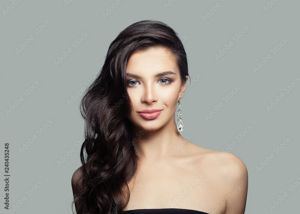 Young woman with curly hair, makeup and silver earrings with diamond Young woman with curly hair, makeup and silver earrings with diamond