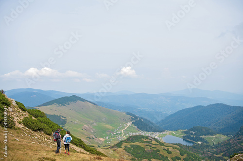 Sporty hikers on path with trekking poles