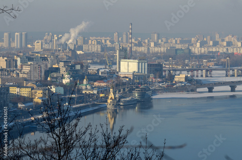 Winter misty view of Dnieper river and Podol district with promenade and buildings. Kiev, Ukraine