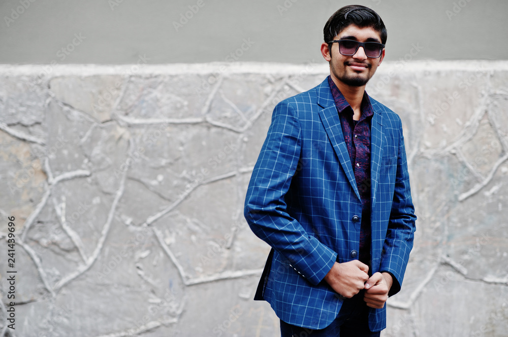 Young indian man on blue suit and sunglasses posed outdoor. Young indian man on blue suit and sunglasses posed outdoor.