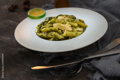 Pasta with pesto sauce and nuts on a the table