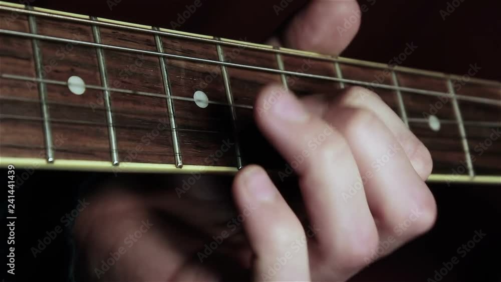 Musician plays the electric guitar. Guitar neck close-up. Musician plays the electric guitar. Guitar neck close-up.