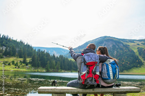 young couple of backpackers near the lake in mountains