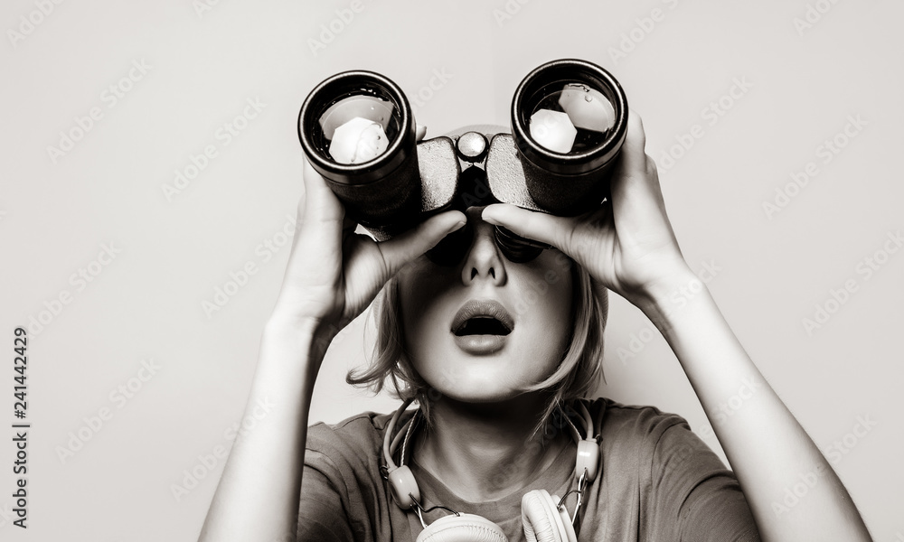 Young style girl with binoculars. Clothes in 1980s style. Image in black and white color style - obrazy, fototapety, plakaty 