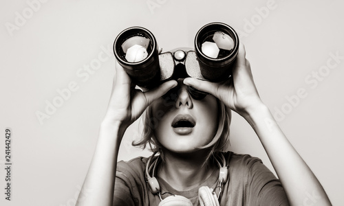 Young style girl with binoculars. Clothes in 1980s style. Image in black and white color style