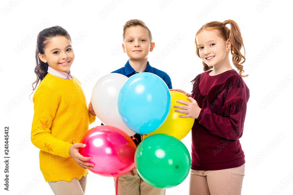 smiling boy and schoolgirls holding colorful balloons and looking at camera isolated on white smiling boy and schoolgirls holding colorful balloons and looking at camera isolated on white